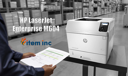 In a warehouse aisle, an HP LaserJet Enterprise M604 printer sits on a black table while a technician in the foreground holds a freshly printed report; overlaid text reads ‘HP LaserJet Enterprise M604’ next to the Item Inc logo.