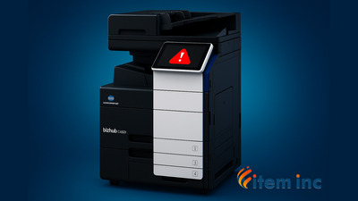 Konica Minolta bizhub C450i multifunction printer on a blue background with a red warning icon on its touchscreen and the Item Inc. logo in the corner.